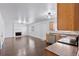 Bright living room featuring a brick fireplace and hardwood floors leading to the kitchen at 15427 E Oberlin Pl, Aurora, CO 80013