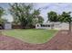 Expansive backyard features a well-manicured lawn, large shade tree, storage shed, and garden beds at 2812 Krameria St, Denver, CO 80207