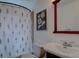 Cozy bathroom featuring floral shower curtain, wood-framed mirror and decorative print at 2812 Krameria St, Denver, CO 80207
