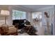 Bright living room featuring hardwood floors, a cozy sofa, and large windows at 2812 Krameria St, Denver, CO 80207