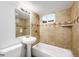 Bathroom featuring a pedestal sink, tiled shower, and a window for natural light at 7841 Oneida St, Commerce City, CO 80022