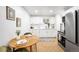 Eat-in kitchen featuring updated appliances, white cabinetry, and modern fixtures at 7841 Oneida St, Commerce City, CO 80022