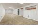A large carpeted basement with a window and a doorway, featuring paneling and recessed lights at 16839 E Amherst E Ave, Aurora, CO 80013