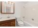 Traditional bathroom featuring a tub and shower combo with a wooden vanity, toilet, and light fixture at 16839 E Amherst E Ave, Aurora, CO 80013
