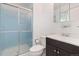 Bright bathroom with a sliding glass door shower, and a vanity with dark cabinets, toilet, and towel rack at 16839 E Amherst E Ave, Aurora, CO 80013