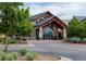 Elegant building entrance with stone pillars, timber accents, and beautifully landscaped surroundings at 16839 E Amherst E Ave, Aurora, CO 80013