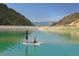 Scenic view of people paddleboarding on a calm, green reservoir with mountains in the background at 16839 E Amherst E Ave, Aurora, CO 80013
