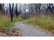 Winding walking path through a wooded area with trees and vegetation at 16839 E Amherst E Ave, Aurora, CO 80013