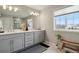 This bathroom features a double vanity, a large mirror, and a big window at 11008 Hayloft St, Parker, CO 80134