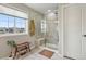 This bathroom features a stand-up glass shower, a large window, and tile floors at 11008 Hayloft St, Parker, CO 80134