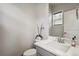 Well-lit half bathroom features a gray vanity, quartz countertop, and modern faucet and fixtures at 11008 Hayloft St, Parker, CO 80134