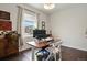 Bright home office featuring a large window with wood desk and classic white folding chairs at 11008 Hayloft St, Parker, CO 80134