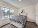 A sunny bedroom with a large window, comfortable bed, and neutral decor at 14222 E Hawaii Cir # F, Aurora, CO 80012