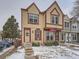 Tan two-story townhouse with American flag, steps, and snow-covered yard at 14222 E Hawaii Cir # F, Aurora, CO 80012