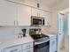 Bright kitchen with stainless steel appliances, white cabinets, and Quartz countertops at 14222 E Hawaii Cir # F, Aurora, CO 80012