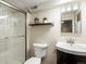Finished basement bathroom with glass enclosed shower, white toilet, and dark wood vanity at 1100 Hudson St, Denver, CO 80220