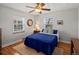Bright bedroom featuring hardwood floors, a ceiling fan, and a large window at 1100 Hudson St, Denver, CO 80220