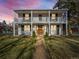 Charming two-story home featuring a double balcony, white facade, and welcoming front yard at 1100 Hudson St, Denver, CO 80220