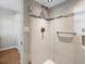 Shower features beige tile with glass door, shower head and handle, as well as metal safety rail at 1100 Hudson St, Denver, CO 80220