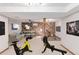 Basement space with fitness machines, a sofa, guitars, and a rustic wood accent wall at 3780 E 117Th Ave, Thornton, CO 80233