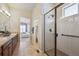 Bright bathroom featuring a glass-enclosed shower, double sink vanity, and neutral tile flooring at 17097 W 87Th Ave, Arvada, CO 80007