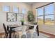 Modern dining area featuring a sleek table, decorative plants, and bright natural lighting at 17097 W 87Th Ave, Arvada, CO 80007