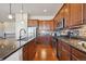 This modern kitchen features wood floors, stainless steel appliances, granite countertops, and wooden cabinets at 17097 W 87Th Ave, Arvada, CO 80007