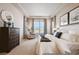 Bright main bedroom with tray ceilings, a large window and a dresser at 17097 W 87Th Ave, Arvada, CO 80007