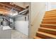 Unfinished basement area with wooden stairs, utilities, washer and dryer at 2062 S Helena St # B, Aurora, CO 80013