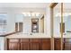 Bathroom vanity with expansive mirror, wood cabinets, and contemporary light fixture at 2062 S Helena St # B, Aurora, CO 80013