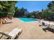 Community pool surrounded by lounge chairs, tables and mature trees at 2062 S Helena St # B, Aurora, CO 80013