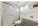 Bathroom with white shower and modern vanity with gray cabinets at 6609 W Mexico Pl, Lakewood, CO 80232