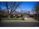 Charming brick home with a well-manicured lawn and mature landscaping at twilight at 6609 W Mexico Pl, Lakewood, CO 80232