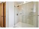Updated shower with seamless glass door and wood-look patterned tile at 6609 W Mexico Pl, Lakewood, CO 80232