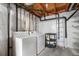 Unfinished basement laundry area includes washer, dryer, and shelving for storage at 18897 E Linvale Pl, Aurora, CO 80013