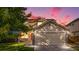 Lovely home featuring a two-car garage, brick accents, and a well-manicured lawn under a vibrant sunset sky at 18897 E Linvale Pl, Aurora, CO 80013