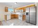 Well-lit kitchen featuring wood cabinets, stainless steel appliances, and tile flooring at 18897 E Linvale Pl, Aurora, CO 80013