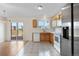 Open kitchen with outdoor access, light wood cabinets, tile flooring, and stainless steel refrigerator at 18897 E Linvale Pl, Aurora, CO 80013