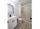 Updated bathroom with a sleek vanity, framed mirror, and shower with glass door at 14608 E 52Nd Ave, Denver, CO 80239