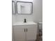 Modern bathroom vanity with black faucet, framed mirror, and crisp white cabinetry at 14608 E 52Nd Ave, Denver, CO 80239