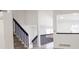 Spacious entryway featuring stairs with dark wood railings and a view of the modern kitchen at 14608 E 52Nd Ave, Denver, CO 80239
