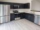 Modern kitchen with stainless steel appliances, dark cabinets and quartz countertops at 14608 E 52Nd Ave, Denver, CO 80239