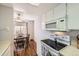 Bright kitchen featuring white cabinetry, modern appliances, and a charming dining area with wood floors at 2201 Sable Blvd # 1008, Aurora, CO 80011