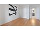 Bright bedroom features hardwood floors, white walls, modern artwork, and ensuite bathroom access at 1313 N Williams St # 1103, Denver, CO 80218