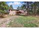 View of home's rear facade featuring fenced-in yard and a cozy patio area, nestled amongst mature trees at 17720 Canterbury Dr, Monument, CO 80132