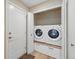 A convenient laundry room features a washer, dryer, wood-look flooring, and storage space for laundry essentials at 17720 Canterbury Dr, Monument, CO 80132