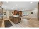 Spacious living room featuring a brick fireplace, wood floors, and kitchen island at 17720 Canterbury Dr, Monument, CO 80132