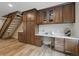 Built-in home office space with wood cabinets, white countertops, and a wooden staircase in background at 17720 Canterbury Dr, Monument, CO 80132
