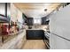 The finished basement kitchen features dark cabinets, stainless steel appliances, and exposed brick at 3008 N York St, Denver, CO 80205