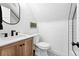 Compact bathroom with wood vanity, modern fixtures, and a decorative black and white floor tile at 3008 N York St, Denver, CO 80205